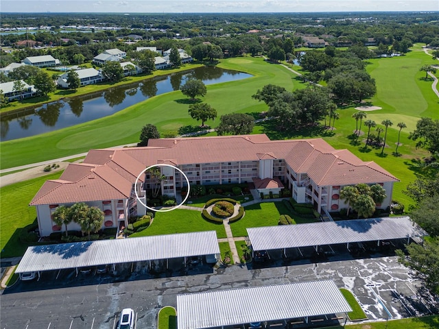 birds eye view of property with golf course view and a water view