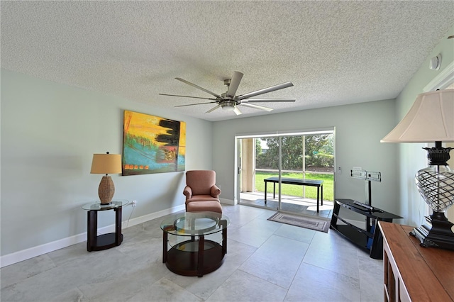 sitting room featuring ceiling fan, baseboards, and a textured ceiling