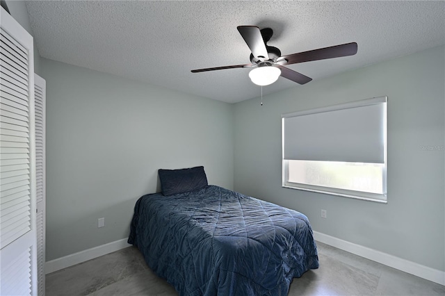 bedroom featuring ceiling fan, a textured ceiling, and baseboards