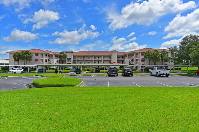 view of property featuring covered and uncovered parking