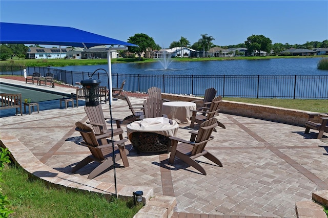 view of patio with a water view, an outdoor fire pit, and fence