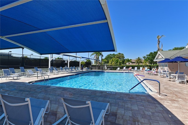 community pool with fence and a patio