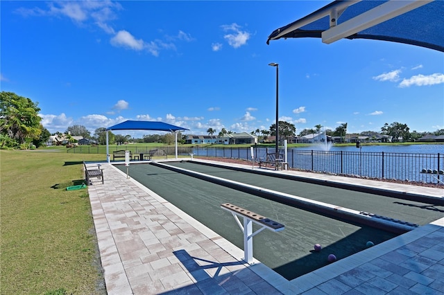 dock area featuring a water view, fence, and a yard