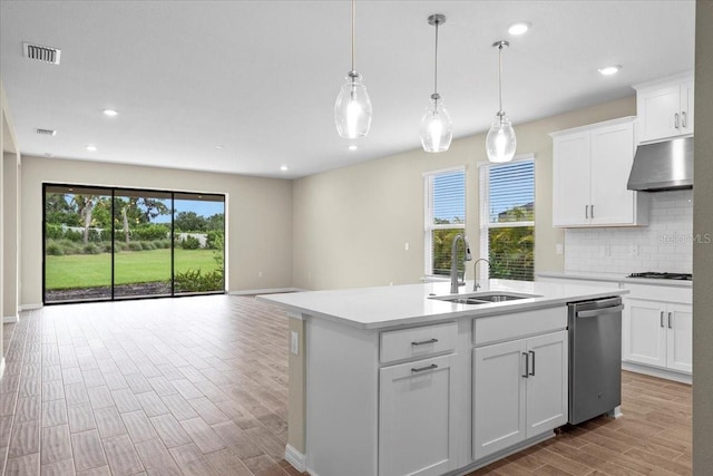 kitchen featuring a center island with sink, light countertops, white cabinets, dishwasher, and under cabinet range hood