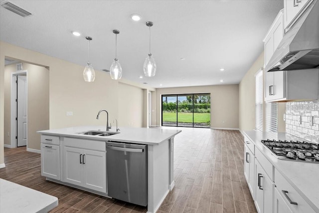 kitchen featuring under cabinet range hood, stainless steel appliances, white cabinets, light countertops, and a center island with sink