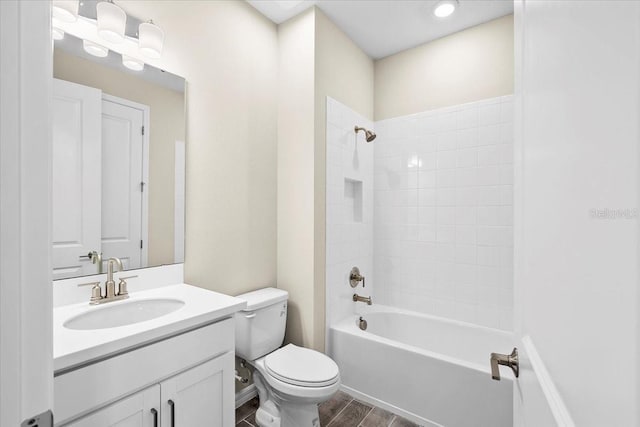 bathroom with toilet, vanity, shower / tub combination, and wood finished floors