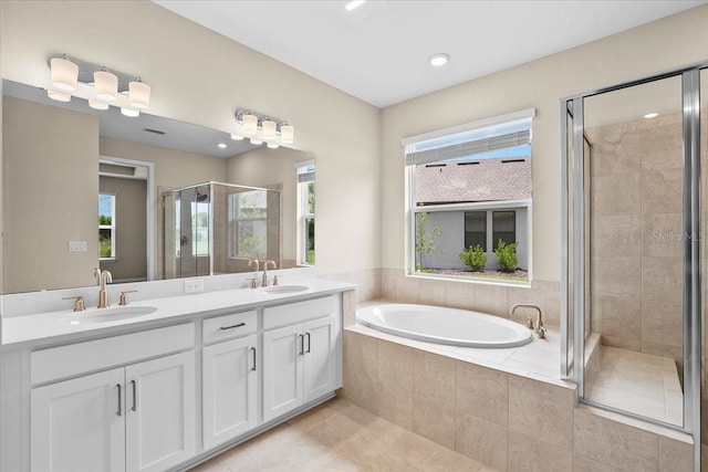 bathroom with double vanity, a stall shower, a sink, and a bath