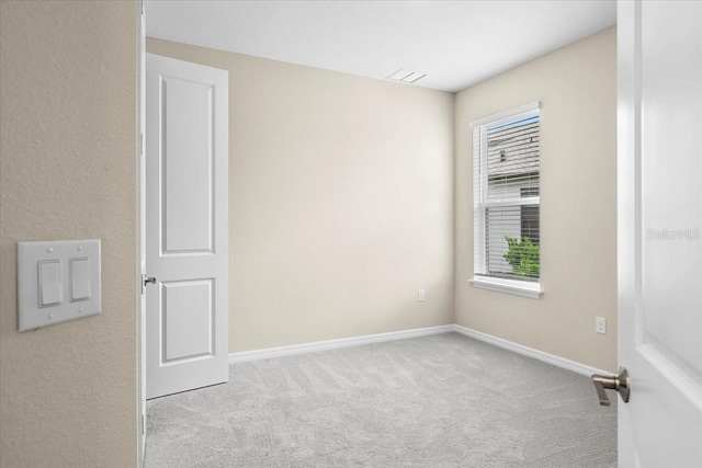 unfurnished room with light carpet and baseboards