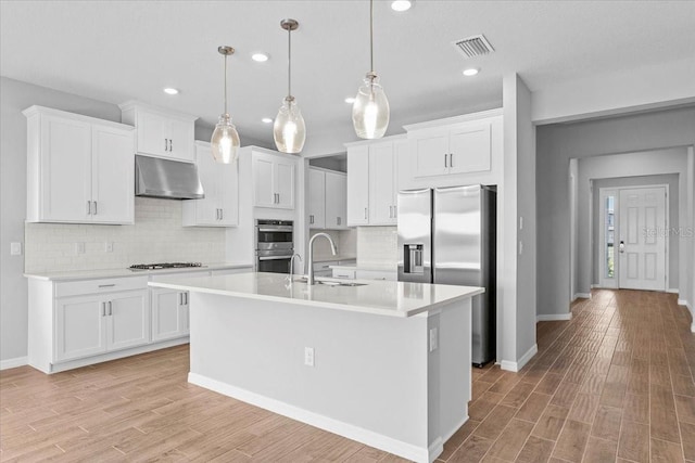 kitchen featuring stainless steel appliances, light countertops, under cabinet range hood, and white cabinetry