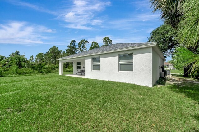 back of house featuring a patio area and a lawn