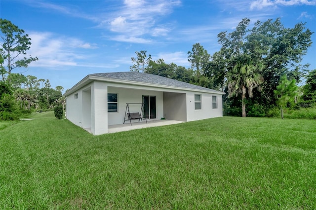 rear view of property featuring a patio and a yard