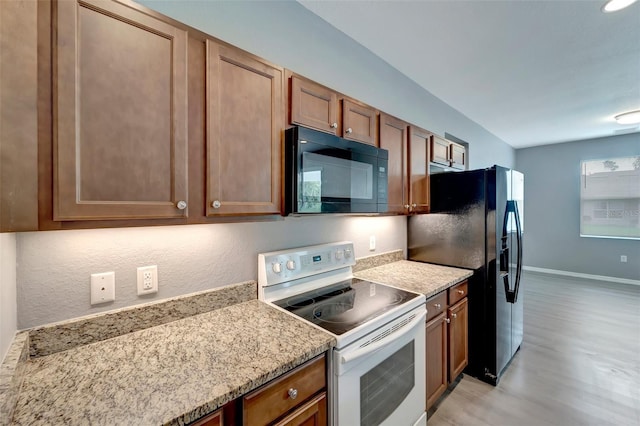 kitchen featuring light wood-type flooring and black appliances