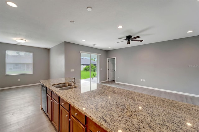 kitchen with light hardwood / wood-style flooring, dishwasher, ceiling fan, light stone countertops, and sink