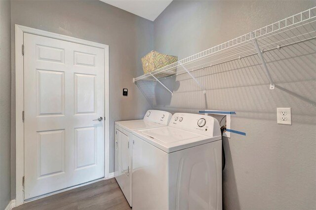 washroom with independent washer and dryer and hardwood / wood-style floors