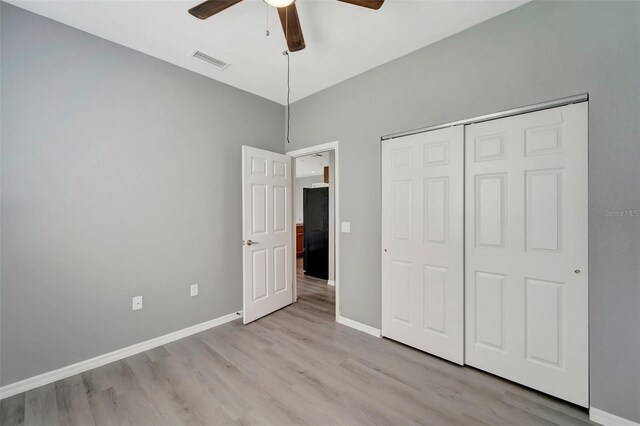 unfurnished bedroom with light hardwood / wood-style floors, a closet, and ceiling fan