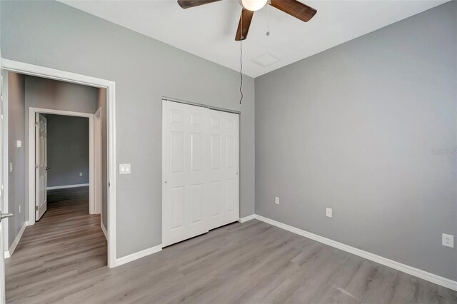 unfurnished bedroom with a closet, hardwood / wood-style floors, and ceiling fan