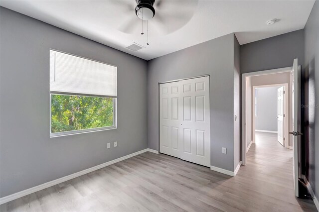 unfurnished bedroom with ceiling fan, hardwood / wood-style floors, and a closet