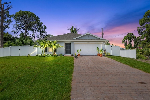 view of front of property with a garage and a lawn