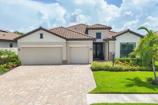 mediterranean / spanish home with a garage and a front lawn