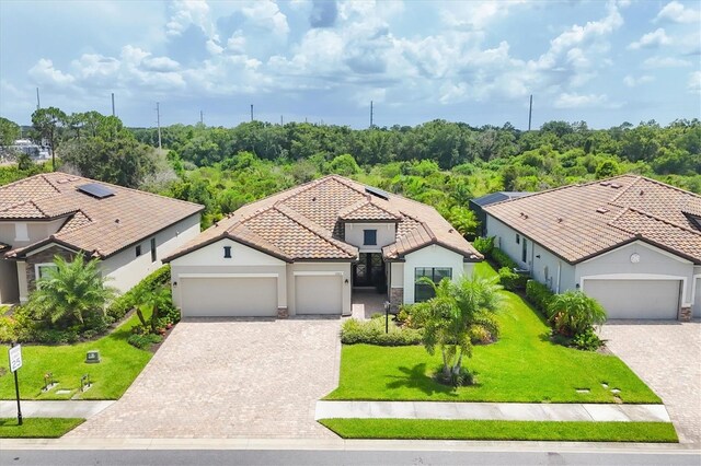 mediterranean / spanish-style home featuring a garage and a front lawn