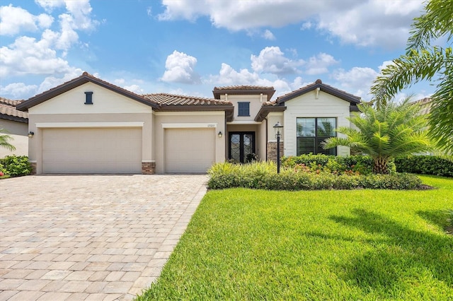 mediterranean / spanish-style home featuring a garage and a front yard