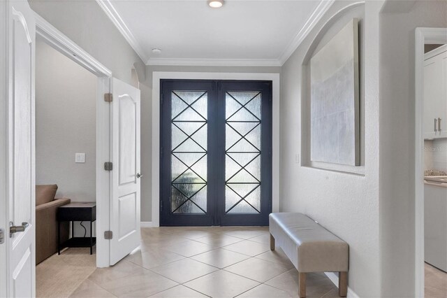 foyer entrance featuring light tile patterned floors, crown molding, and french doors