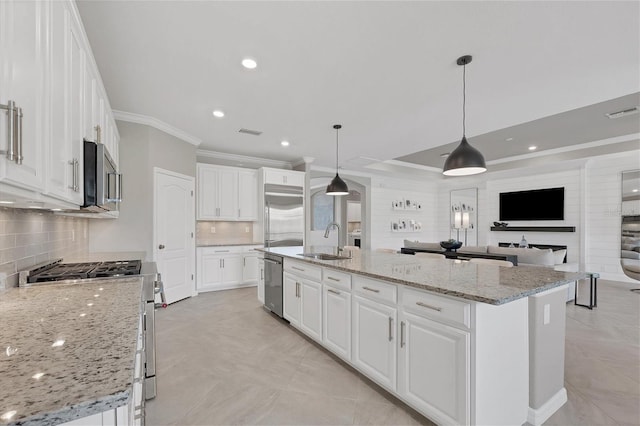 kitchen featuring white cabinets, a center island with sink, sink, decorative backsplash, and premium appliances