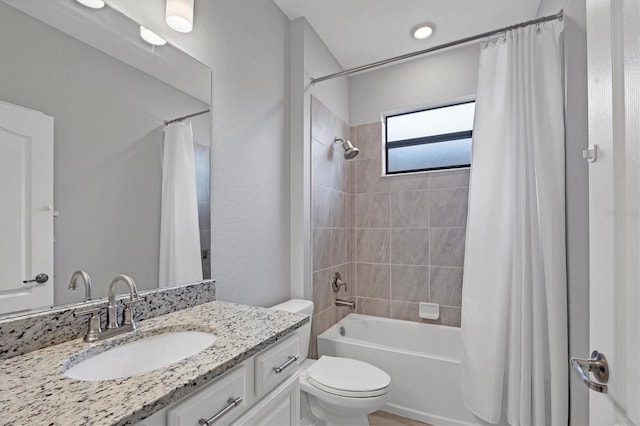 full bathroom featuring vanity, shower / bathtub combination with curtain, and toilet