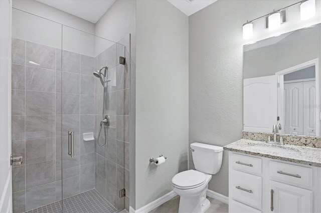 bathroom featuring toilet, vanity, and an enclosed shower