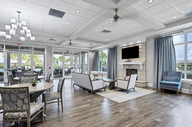 living room with a wealth of natural light, a fireplace, french doors, and dark wood-type flooring