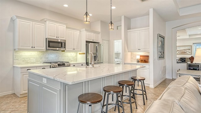 kitchen with light tile patterned flooring, stainless steel appliances, and tasteful backsplash