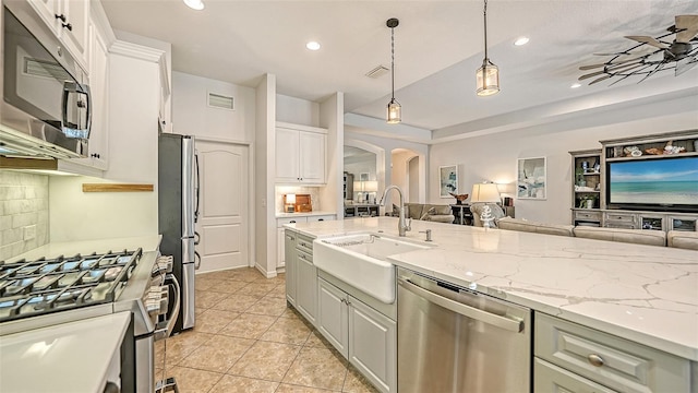 kitchen with white cabinetry, pendant lighting, sink, appliances with stainless steel finishes, and light tile patterned floors