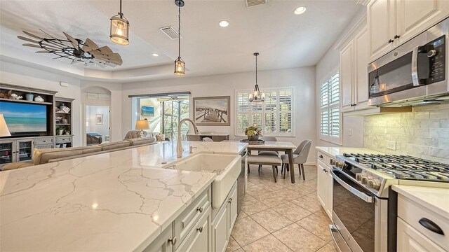 kitchen featuring a healthy amount of sunlight, pendant lighting, backsplash, and stainless steel appliances