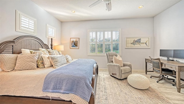 bedroom with light hardwood / wood-style flooring, a textured ceiling, and ceiling fan