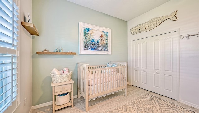 bedroom featuring light hardwood / wood-style floors, a closet, and a crib