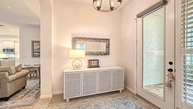 tiled entrance foyer featuring a notable chandelier