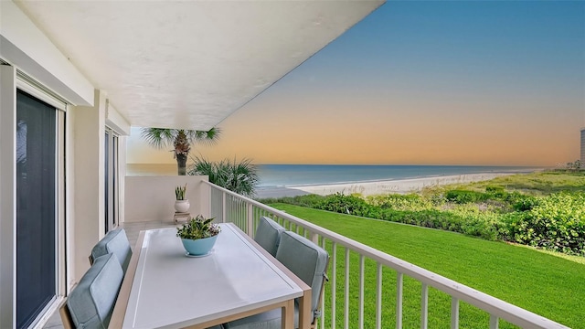 balcony at dusk with a beach view and a water view