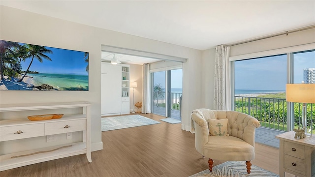 interior space featuring a water view, wood-type flooring, and ceiling fan