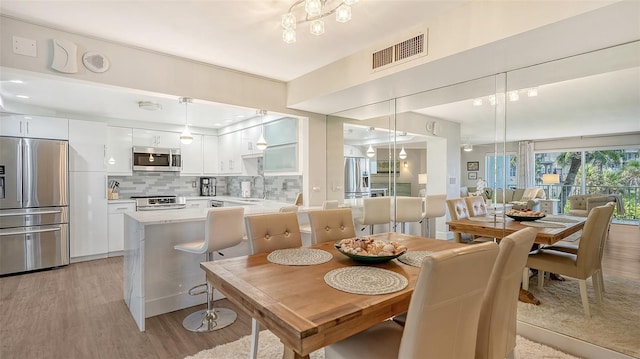 dining area featuring light hardwood / wood-style flooring and sink