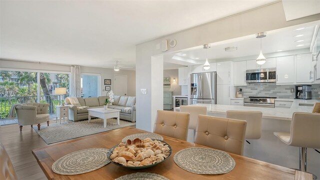 dining space with sink, ceiling fan, and hardwood / wood-style floors