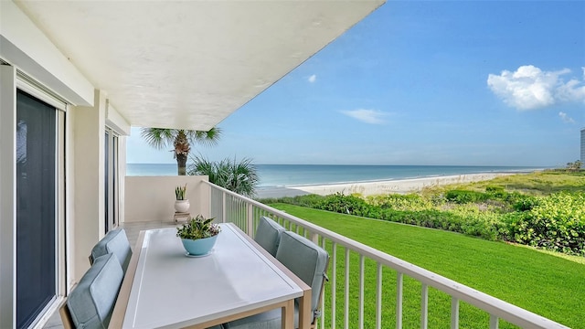 balcony featuring a water view and a beach view