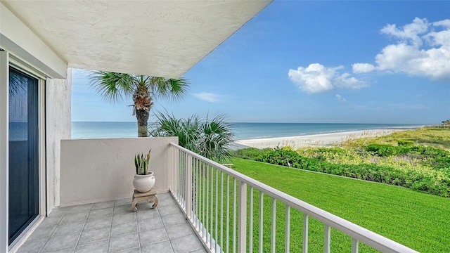 balcony with a water view and a view of the beach