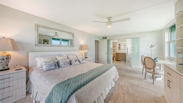 bedroom featuring ceiling fan, connected bathroom, and light colored carpet