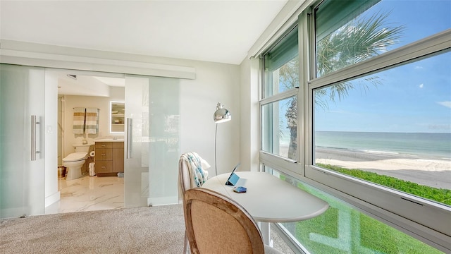 dining space featuring light tile patterned flooring, a water view, and a beach view