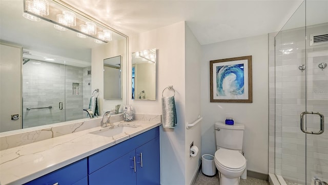 bathroom with a shower with door, vanity, and toilet