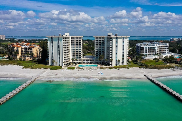 birds eye view of property featuring a water view and a beach view