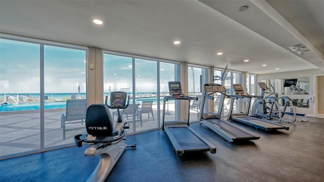 gym featuring a water view and expansive windows