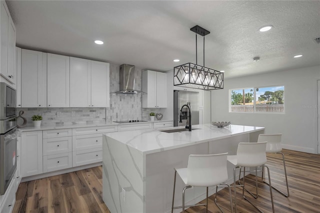 353 Suwanee Ave, Sarasota, FL 34243 - kitchen featuring backsplash, a sink, wood finished floors, stainless steel appliances, and wall chimney range hood