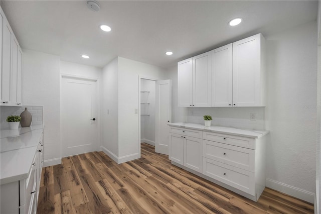 353 Suwanee Ave, Sarasota, FL 34243 - kitchen with white cabinets, wood finished floors, and tasteful backsplash