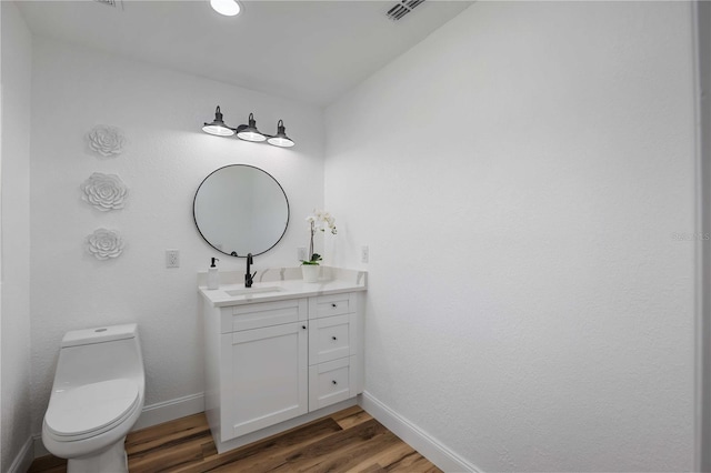353 Suwanee Ave, Sarasota, FL 34243 - half bath with vanity, toilet, baseboards, visible vents, and wood finished floors